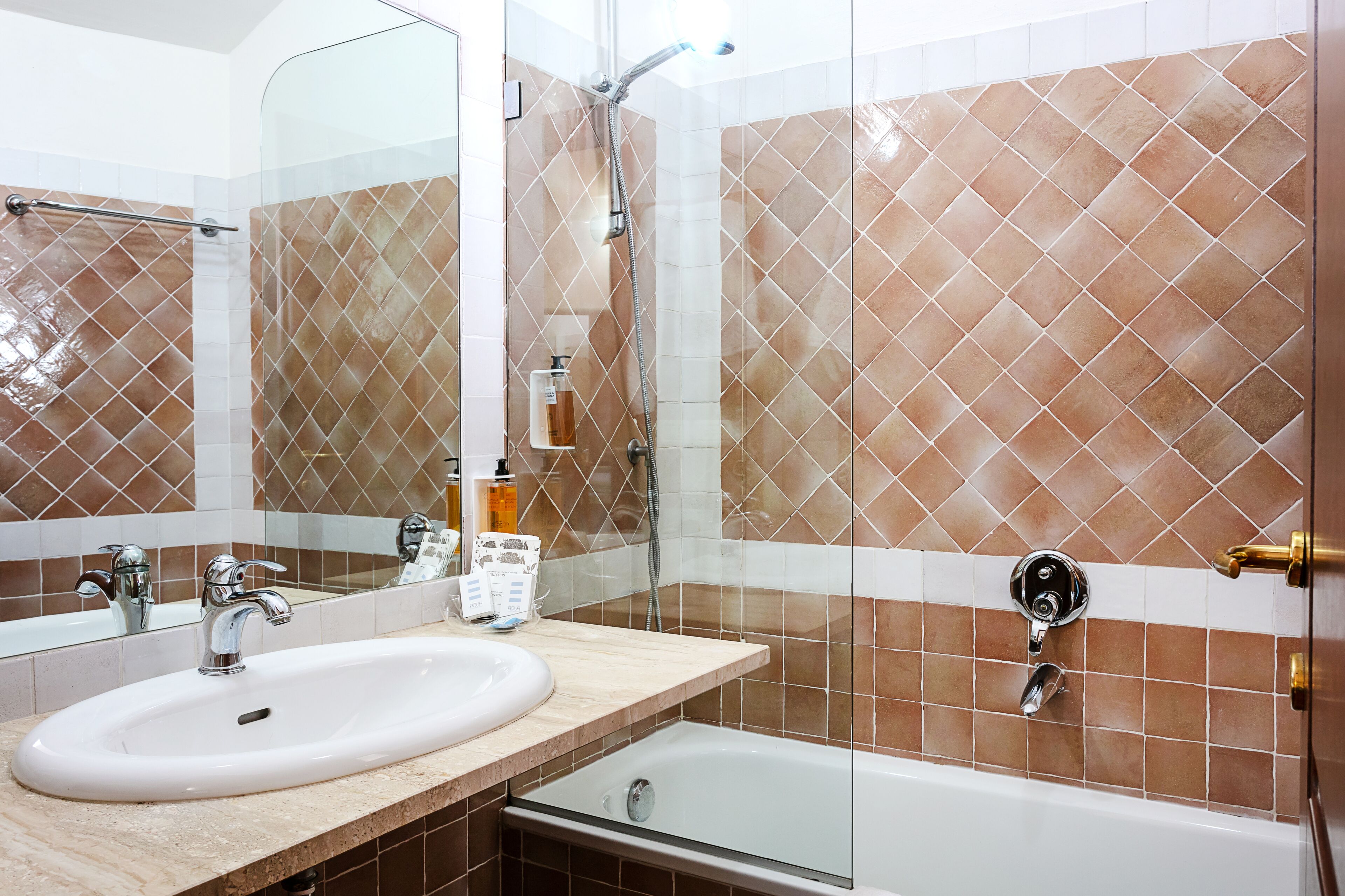 Une salle de bain équipée d’un lavabo, d’un miroir, d’une douche et d’une baignoire.