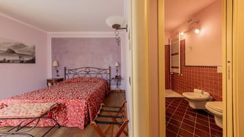 Un dormitorio con cama, mesitas de noche, lámpara y un cuadro en la pared.