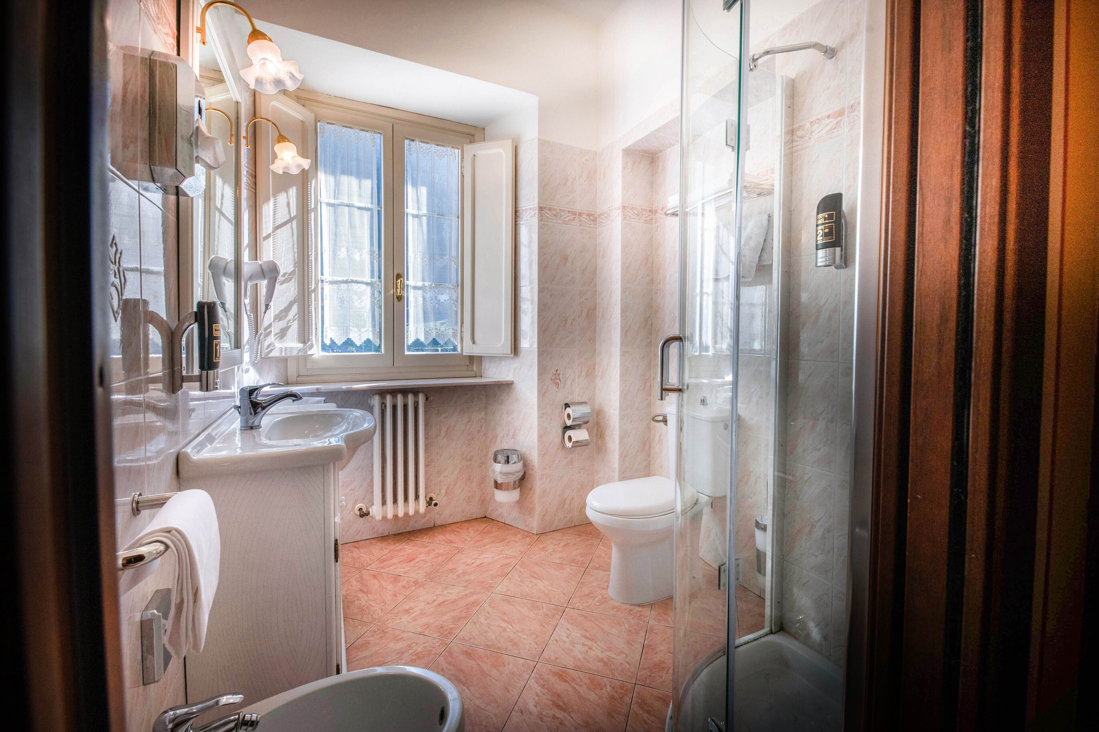 A modern bathroom with a glass shower, a white sink, and a toilet.