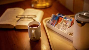 Un vassoio con una tazza di caffè, un libro, occhiali e una scatola di fazzoletti.