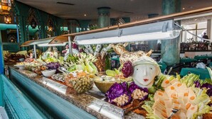 Un buffet proposant une variété de plats et agrémenté d’une tête de mouton décorative en guise de centre de table.