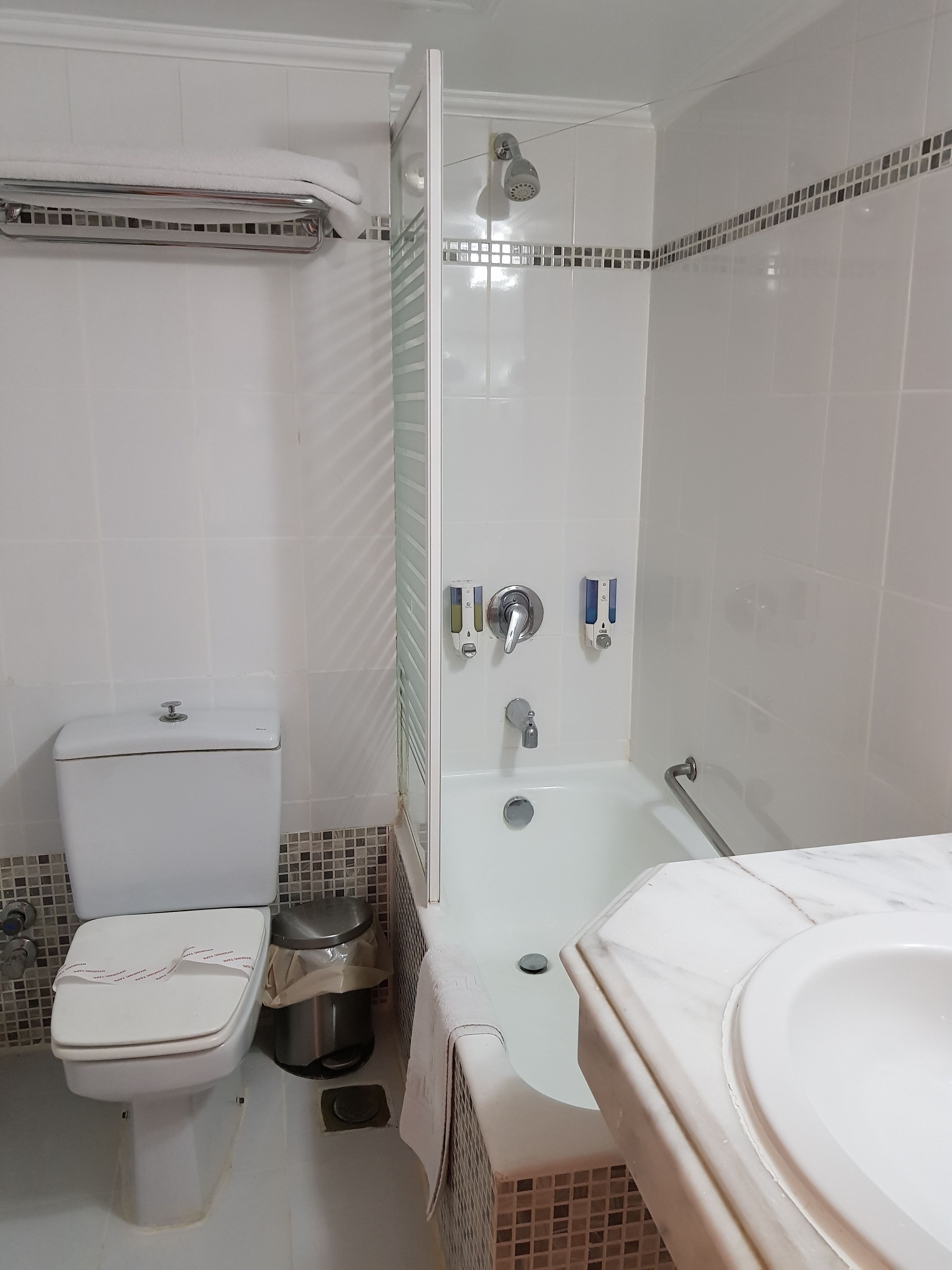 Un baño con inodoro, bidé, bañera y cabina de ducha.