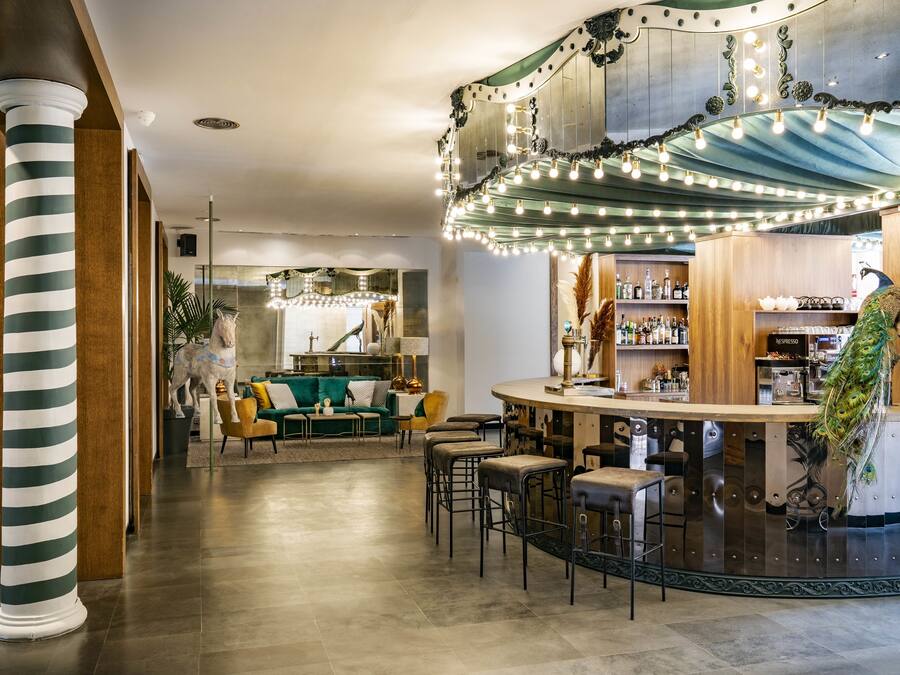 Uma área de bar com banquetas, um balcão e uma decoração com pavão.