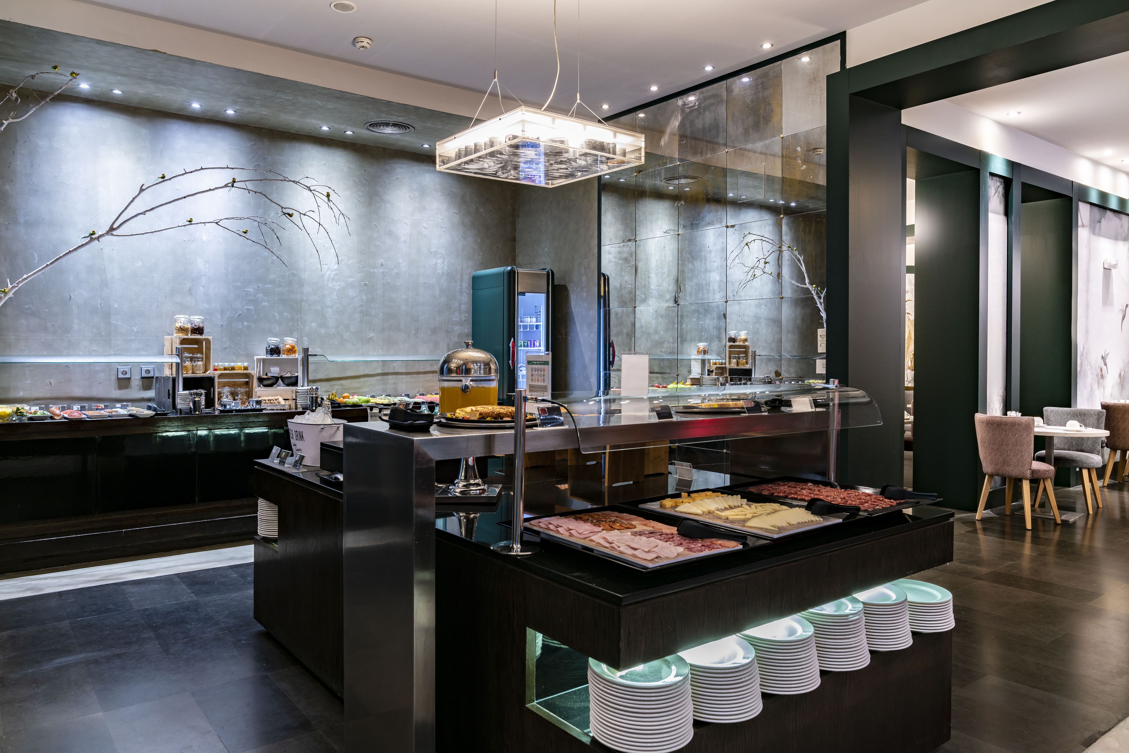 Un espace buffet proposant une variété de plats, une cloison en verre et un aménagement intérieur moderne.