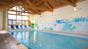 An indoor swimming pool with wooden beams, clear windows, and a mural of mountains. - Résidence et Chalets de la Fontaine du roi  (Saint-Jean-d'Arves)