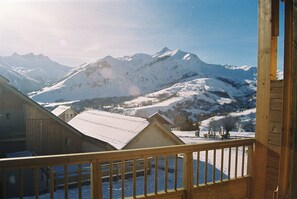 A mountain cabin with a wooden balcony overlooking a snowy landscape and distant mountains. - Résidence et Chalets de la Fontaine du roi  (Saint-Jean-d'Arves)