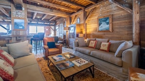 A cozy log cabin interior with a sofa, armchairs, and a coffee table. - Residence Pierre & Vacances Premium L'Ecrin des Neiges (Tignes)