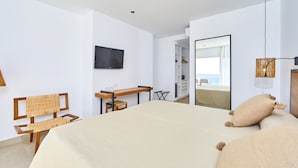 A modern bedroom with a large bed, a desk, a chair, a TV, and a mirror. - FERGUS Conil Park (Conil de la Frontera)