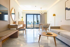 A modern hotel room with a balcony, a dining area, and a seating area. - Hipotels Barrosa Palace & SPA (Chiclana de la Frontera)