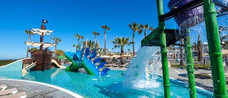 A water park with a pirate ship, palm trees, and a water slide.