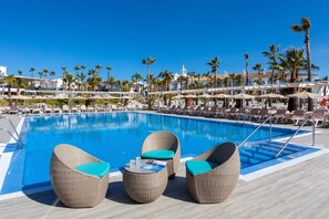 Et poolområde med fletningsloungestole og en pool.