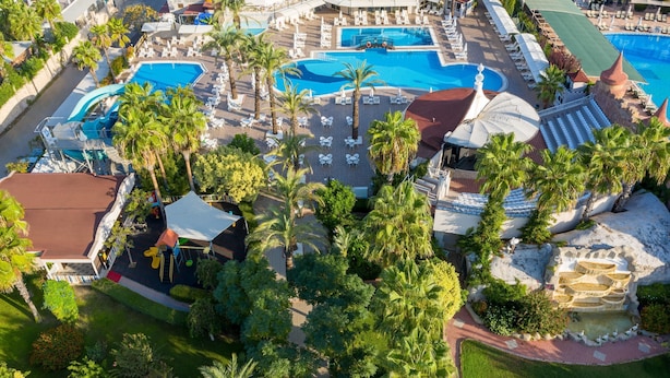 An aerial view of a resort with multiple swimming pools, palm trees, and lounge areas. - Aydinbey Famous Resort - Ultra All Inclusive (Serik)