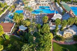 An aerial view of a resort with multiple swimming pools, palm trees, and lounge areas. - Aydinbey Famous Resort - Ultra All Inclusive (Serik)