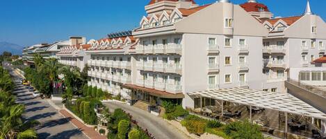 A hotel with multiple floors, balconies, and a covered outdoor area with seating.