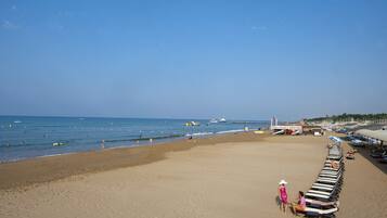 Praia particular, espreguiçadeiras, guarda-sóis, toalhas de praia
