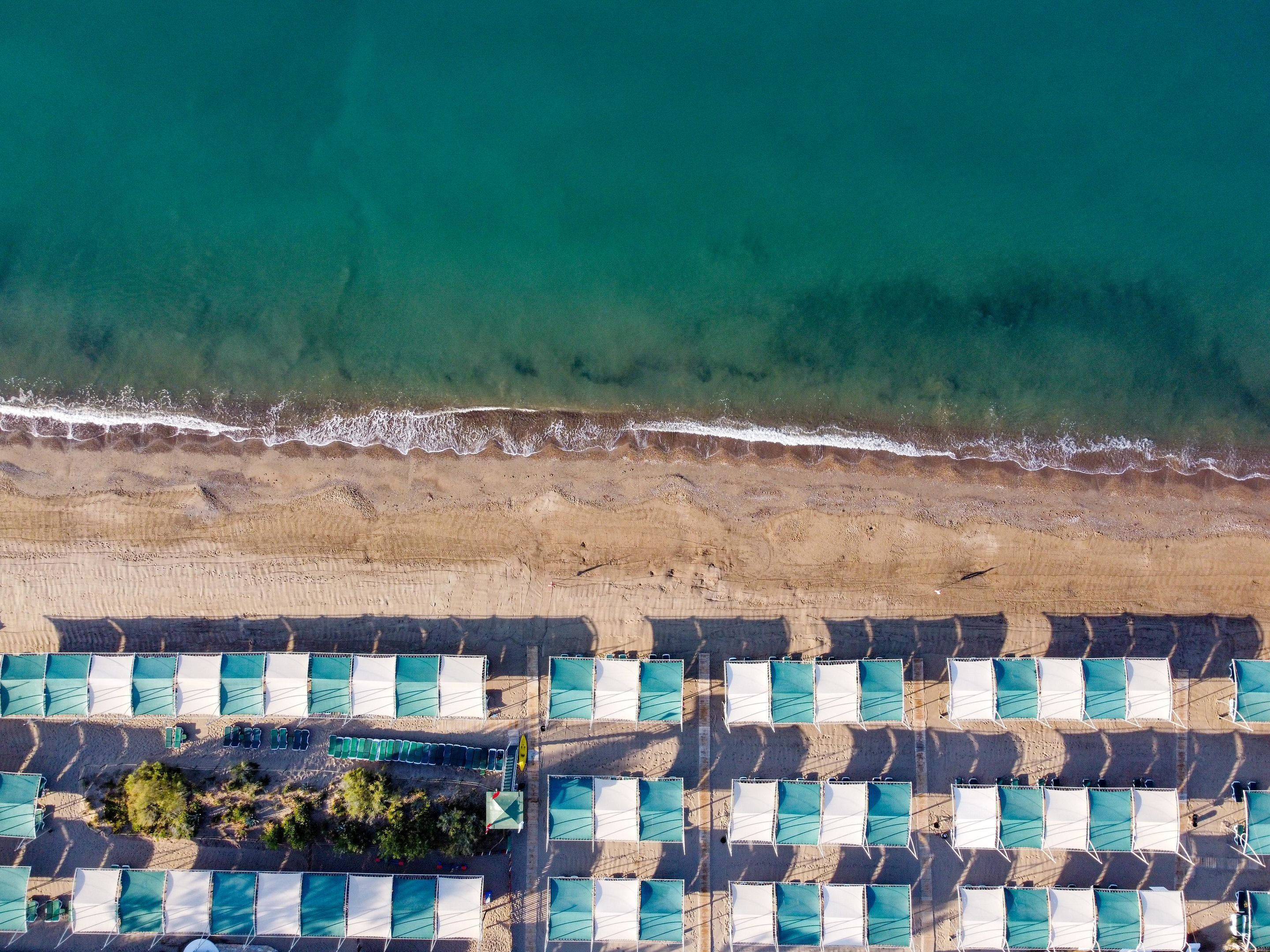 Een privéstrand, ligstoelen aan het strand, parasols, strandlakens