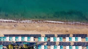 Aan een privéstrand, ligstoelen, parasols, strandlakens