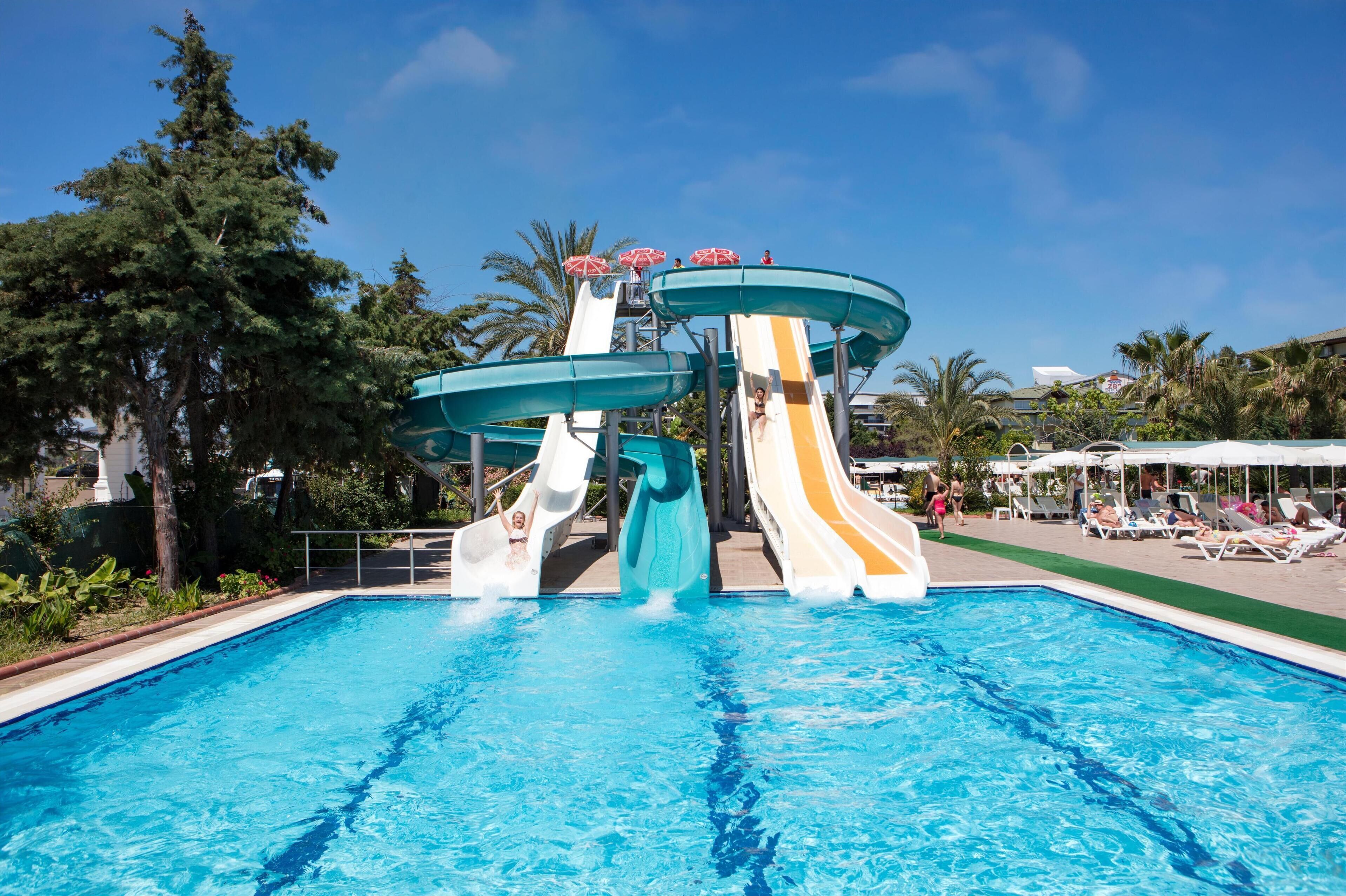 A swimming pool with water slides and lounge chairs.