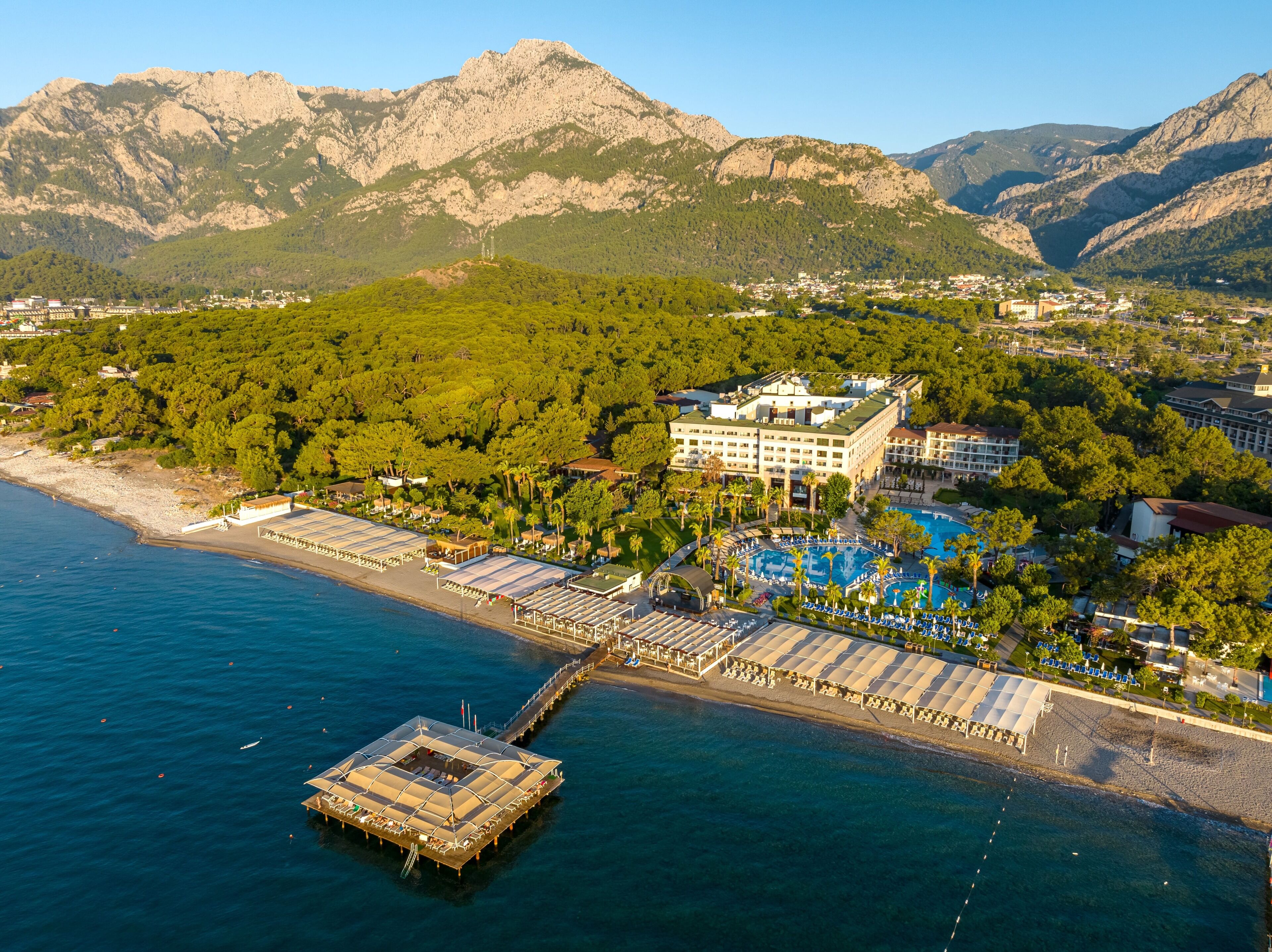 Un hôtel situé sur la côte, doté d’une piscine, d’une jetée et offrant une vue sur les montagnes.