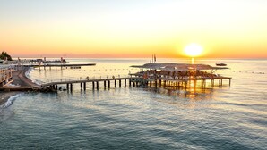 A pier extending into calm waters with a sunset in the background. - Mirada Del Mar Hotel - All Inclusive (Kemer)