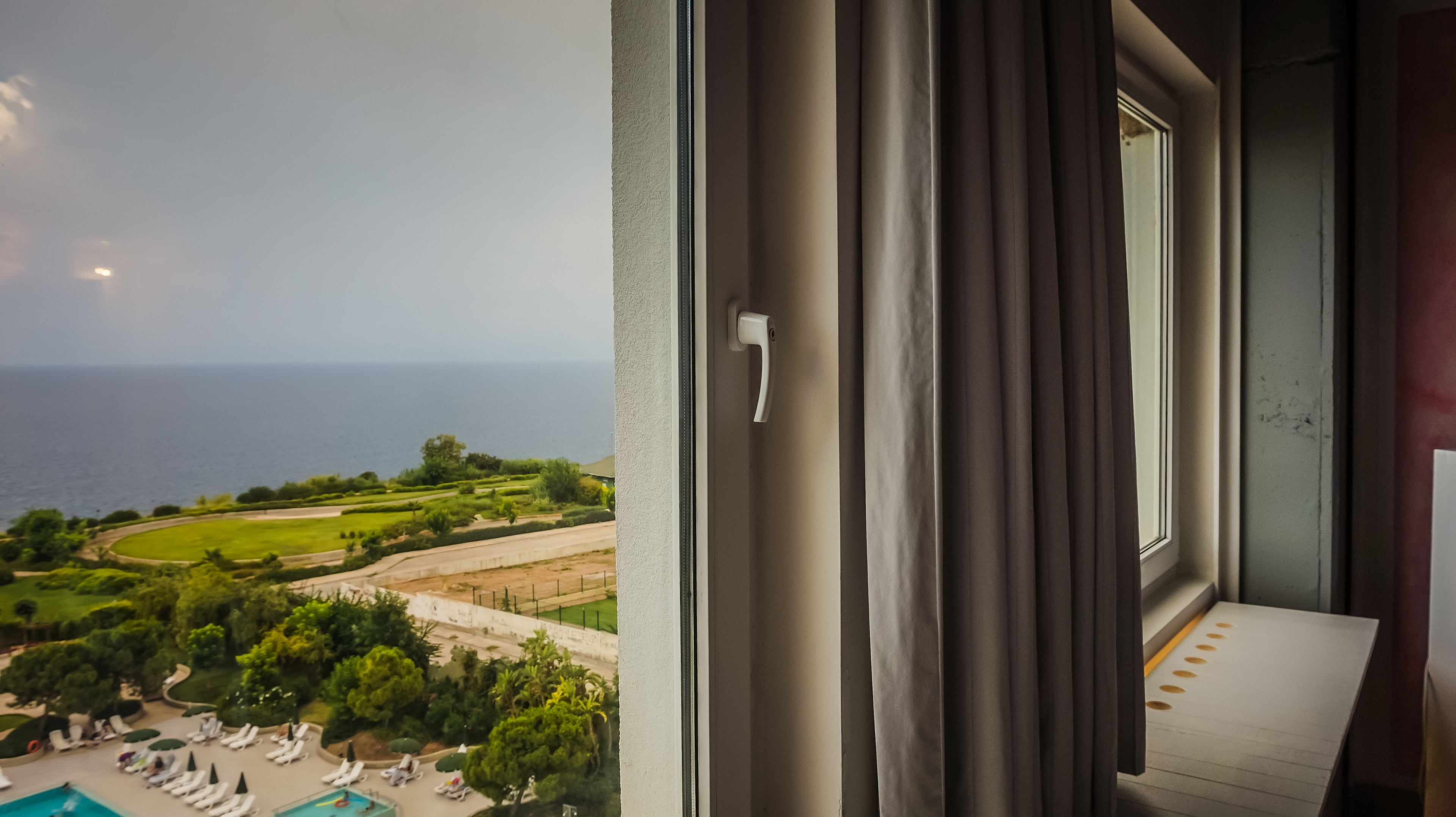 Un balcón con vistas al mar, una piscina y un campo de golf.