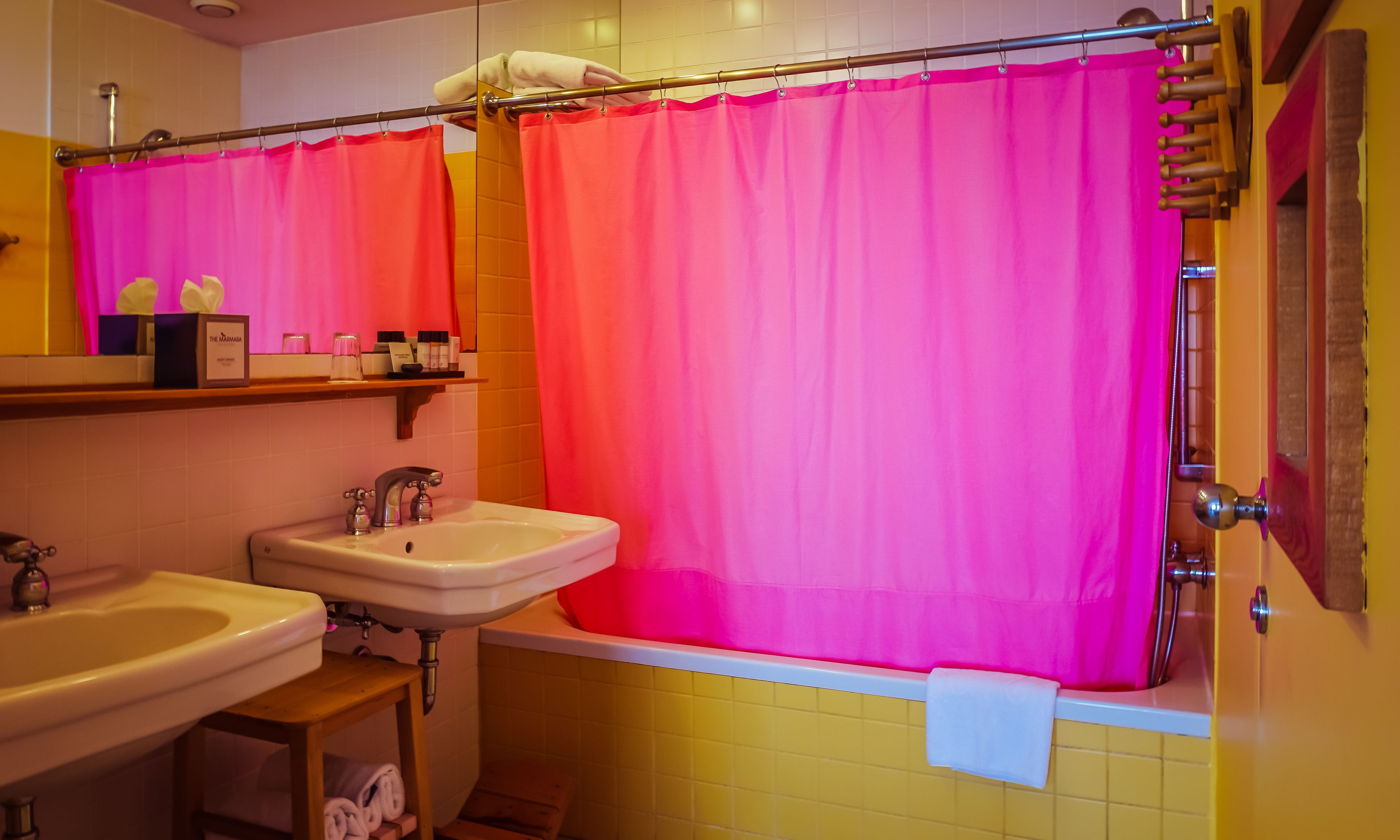 Ein Badezimmer mit rosa Duschvorhang, Waschbecken und Spiegel.