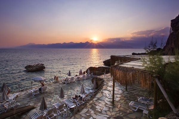 Rannalla, aurinkotuoleja, aurinkovarjoja, rantapyyhkeitä