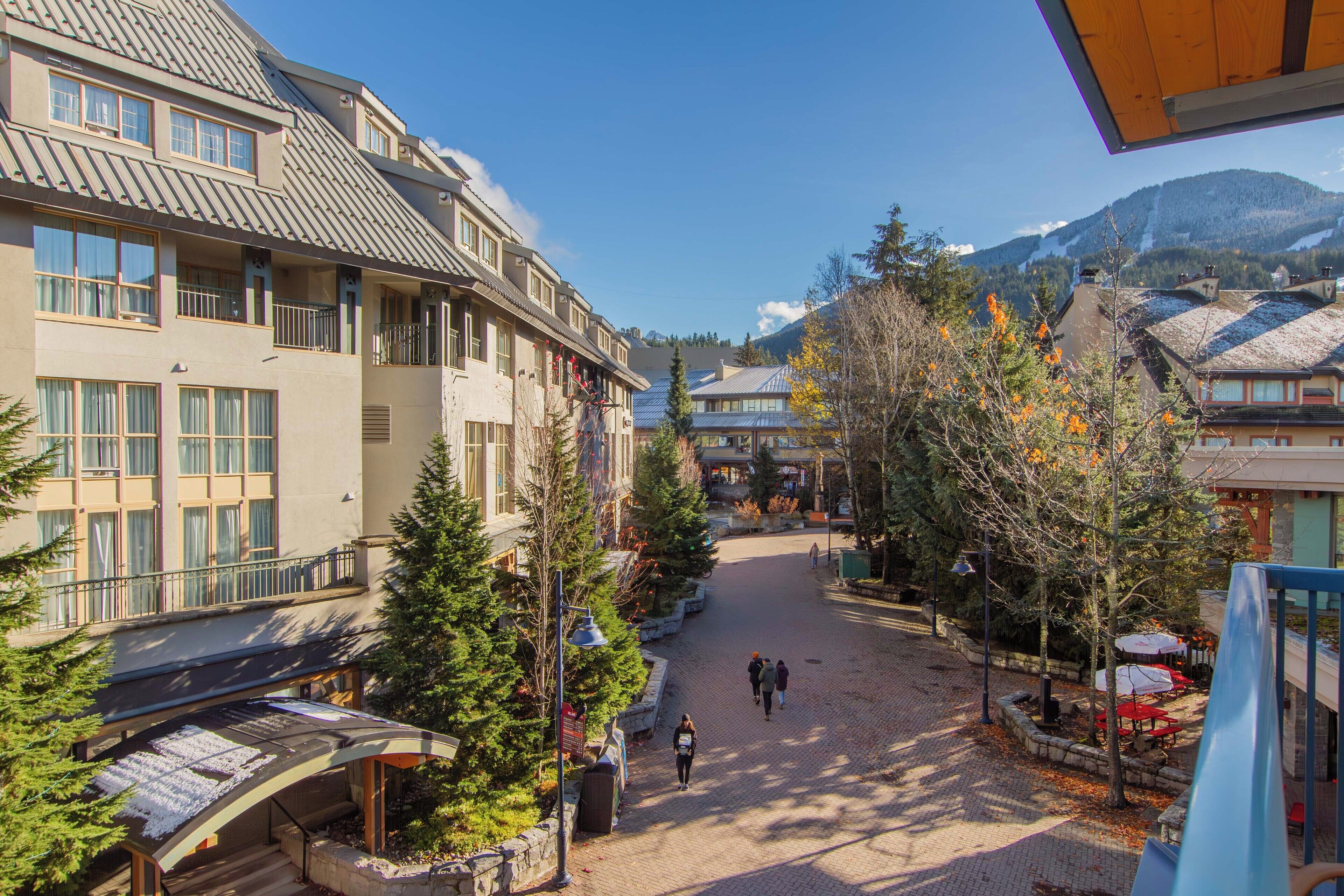 A hotel with a central courtyard, multiple floors, and a mountain backdrop.