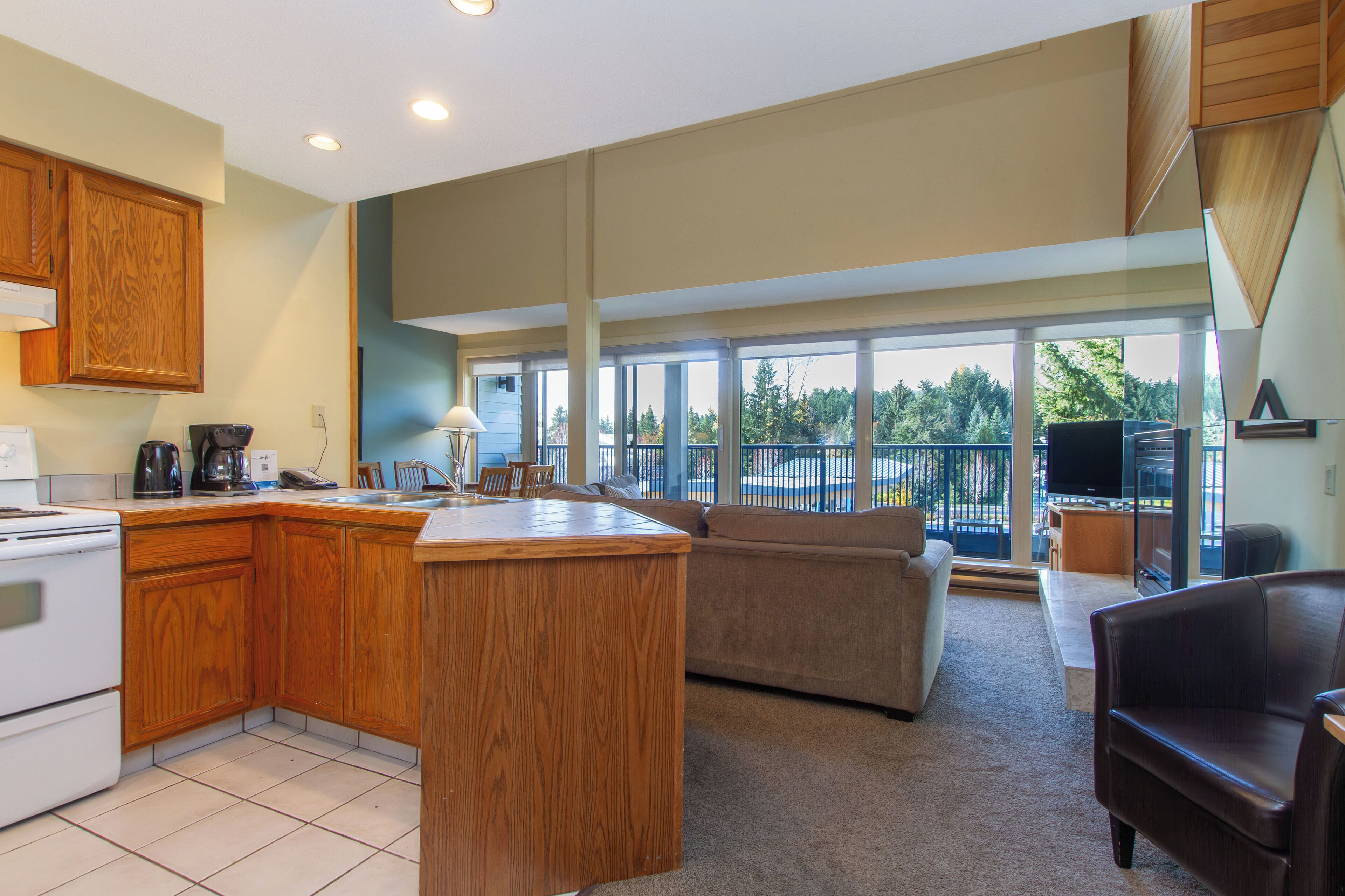 A spacious kitchen with wooden cabinets, a large island, and a dining area with a sofa and chairs.