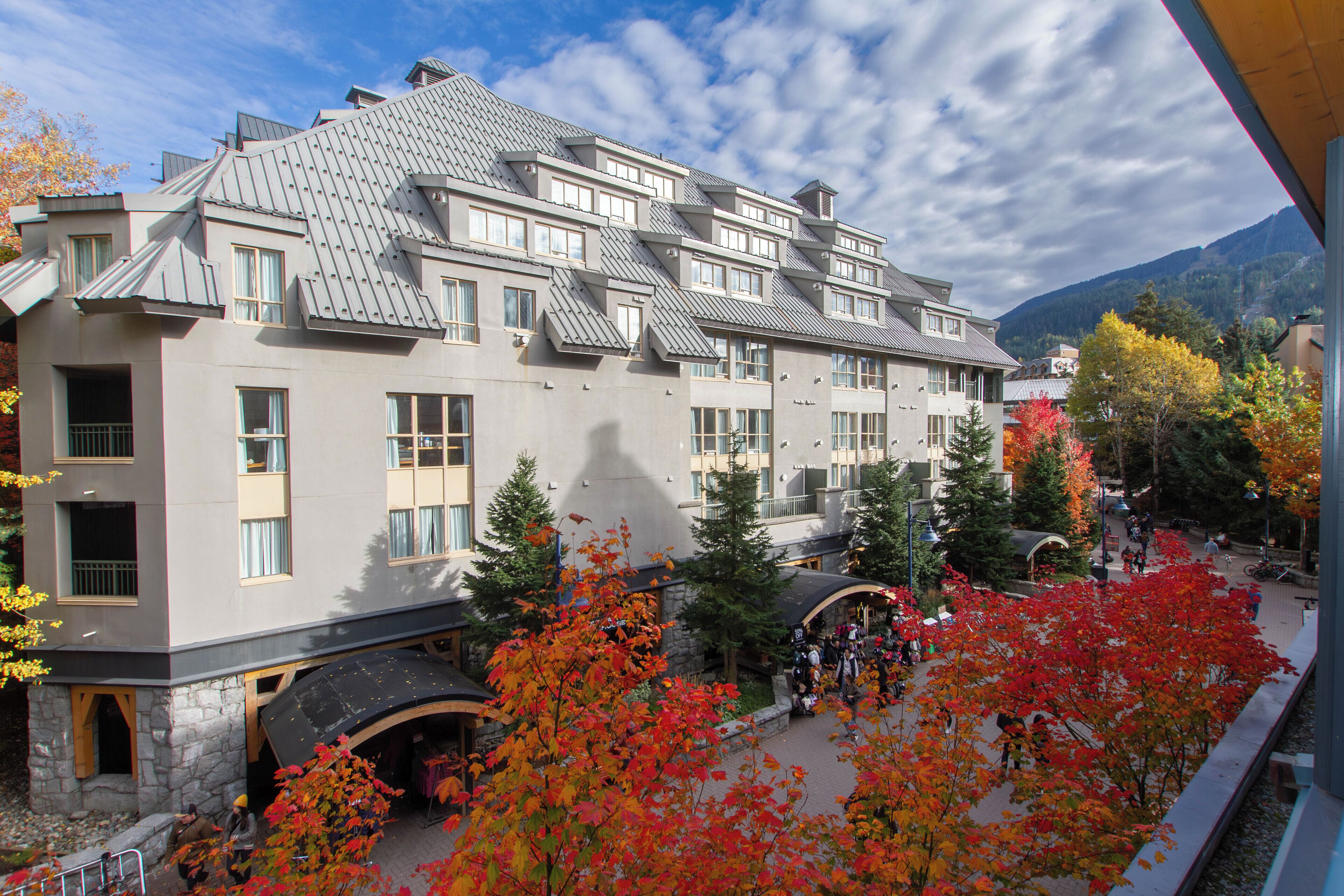 A multi-story hotel with a modern architectural design, featuring a prominent roof and multiple balconies.