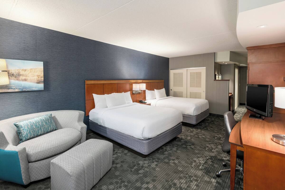 Een hotelkamer met een groot bed, een bureau, een stoel en een bank.
