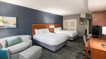 Una habitación de hotel con una cama grande, un escritorio, una silla y un sofá.