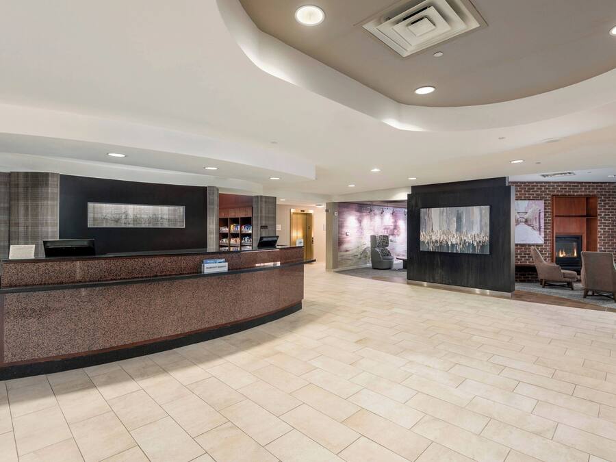 A modern reception area with a curved reception desk, a fireplace, and seating area.