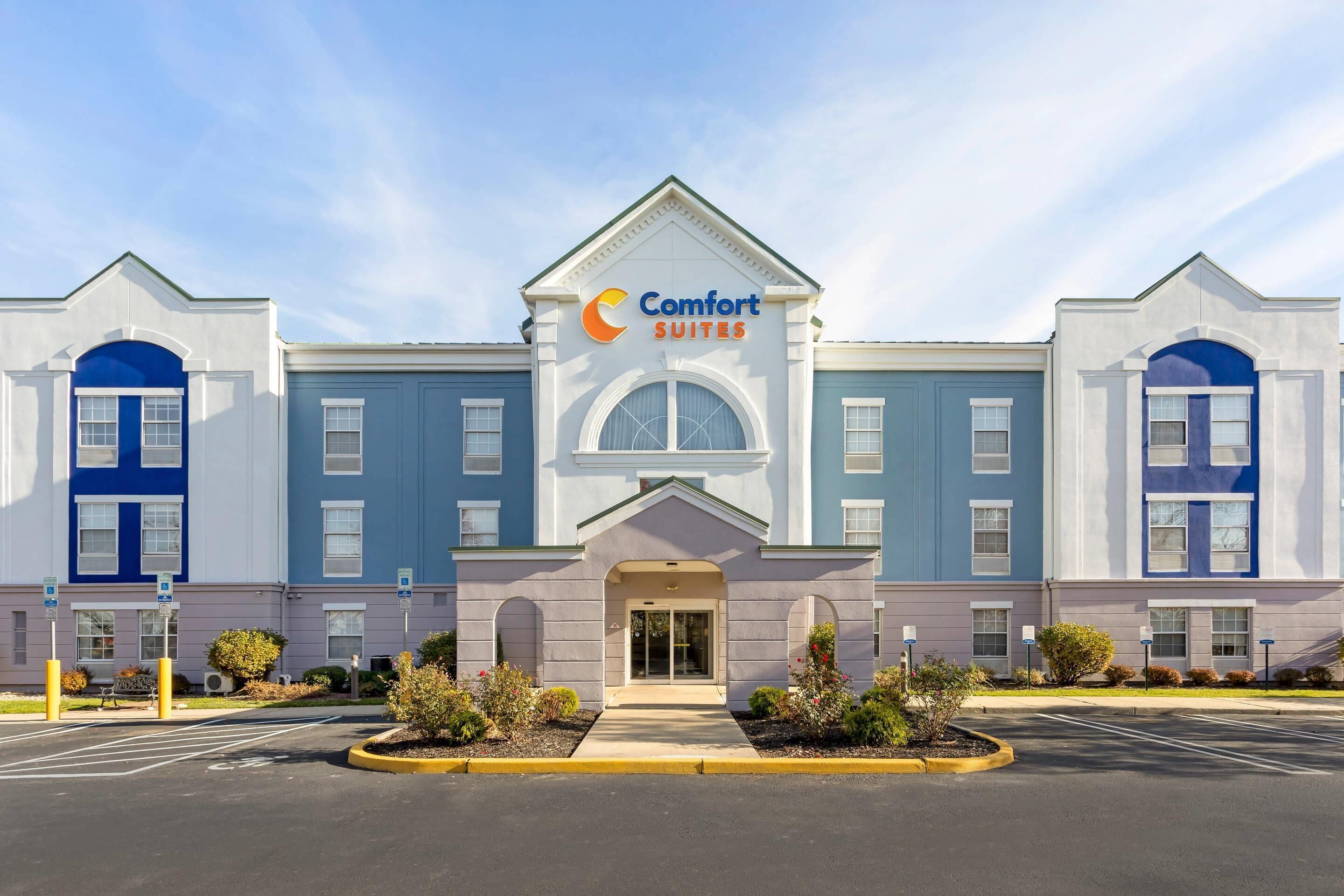 Un hôtel Comfort Suites doté d’une façade symétrique, de grandes fenêtres et d’une entrée centrale.