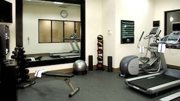 A gym with treadmills, a stationary bike, and a weight bench.