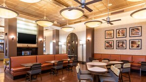 Un restaurante con cabinas, mesas y un ventilador de techo.