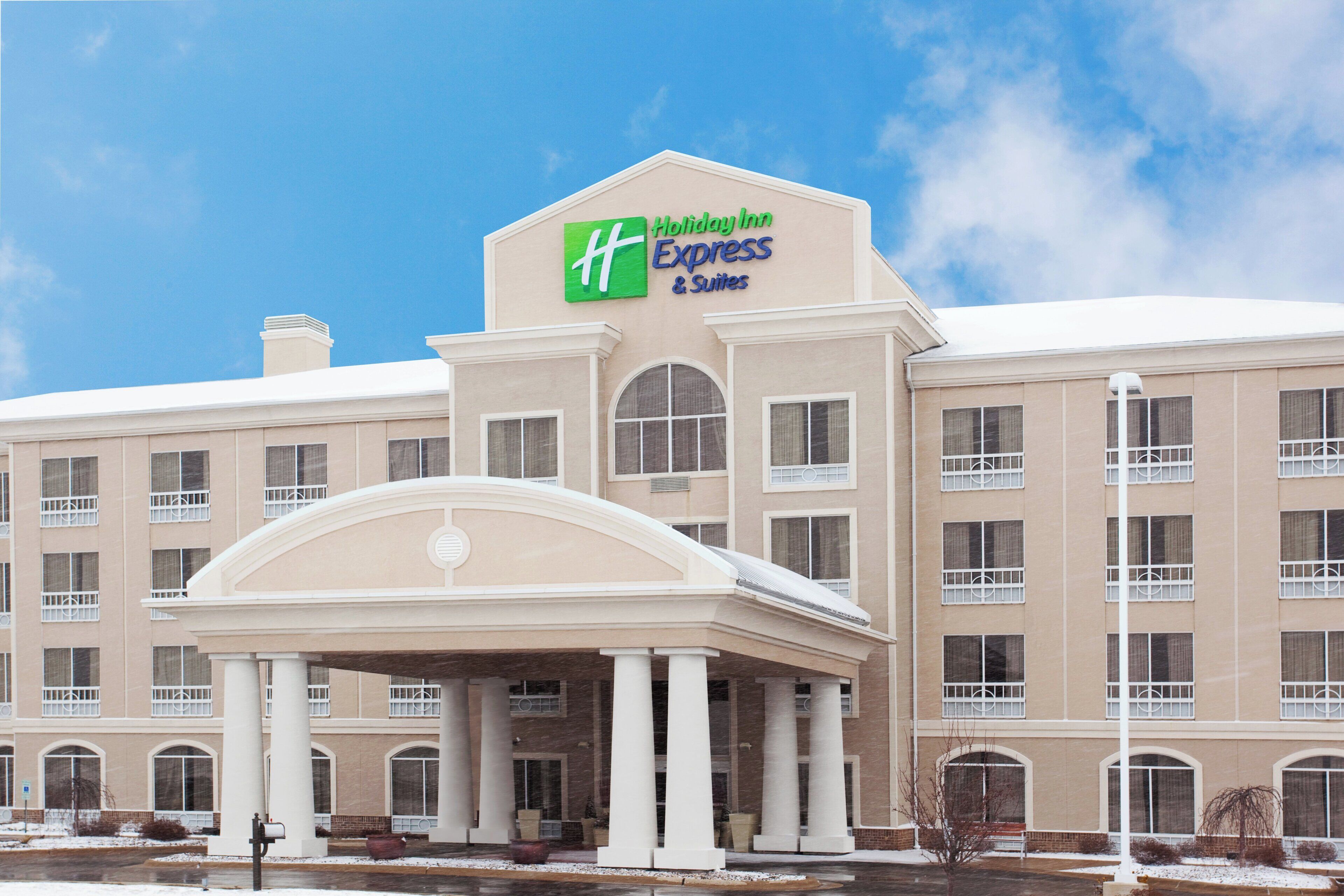Un grand bâtiment d’hôtel avec une enseigne bien visible indiquant « Holiday Inn Express & Suites ».
