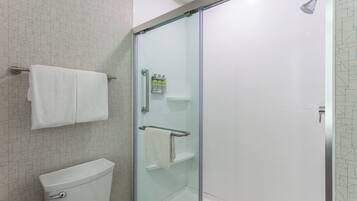 A bathroom with a glass-enclosed shower, a toilet, and a towel rack.