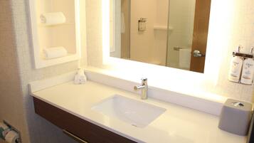 Une salle de bain avec un lavabo blanc, un miroir et un porte-serviettes.