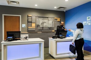 A reception desk with a computer and a phone, a sign indicating 'Holiday Inn Express & Suites', and a 'STAFF ONLY' sign on the wall. - Holiday Inn Express Hotel & Suites Bremen by IHG (Bremen)