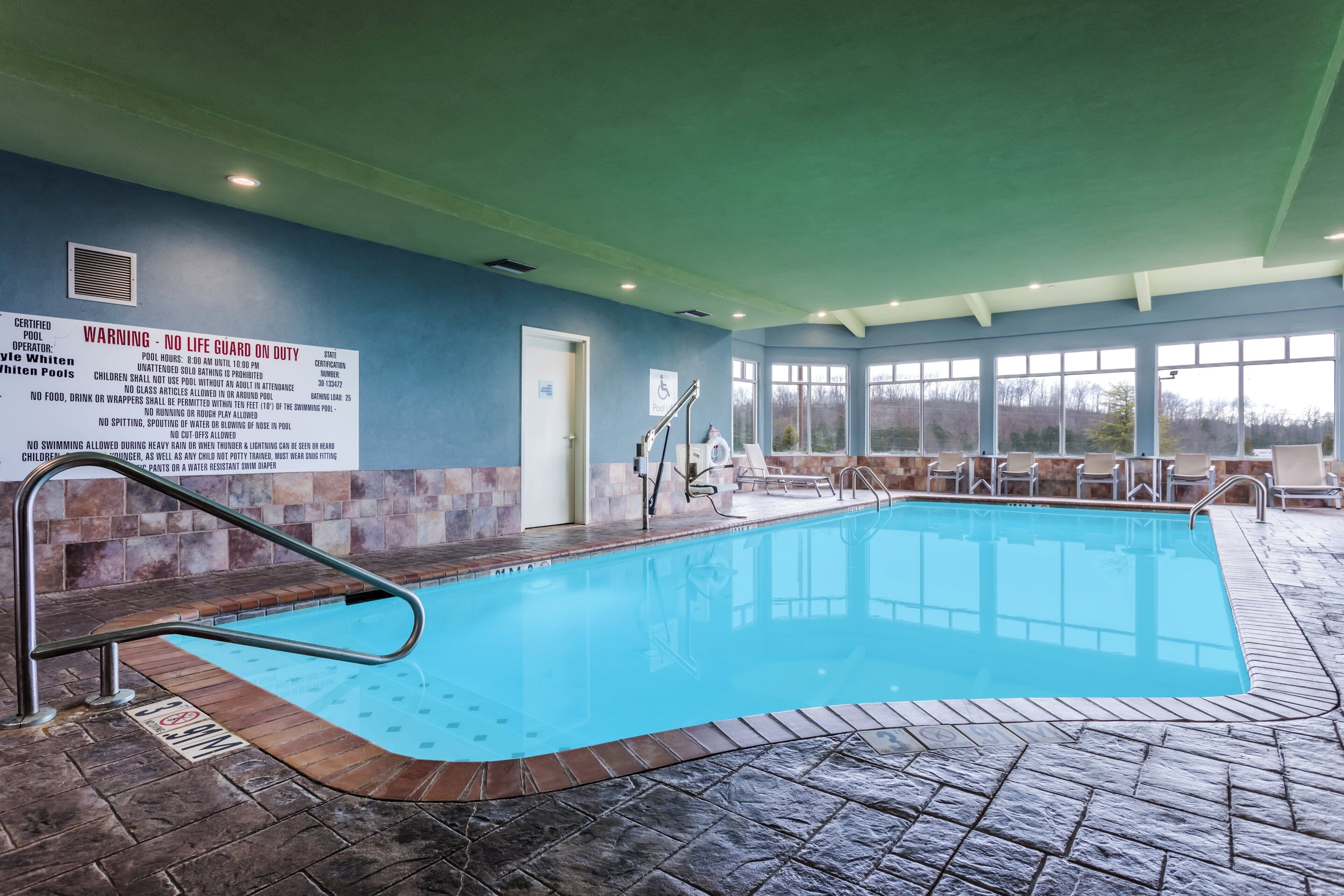 Una piscina techada, sillones reclinables de piscina