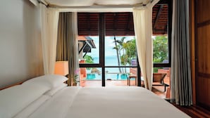 A hotel room with a large bed, a view of a pool, and a wooden ceiling. - Renaissance Koh Samui Resort & Spa (Koh Samui)