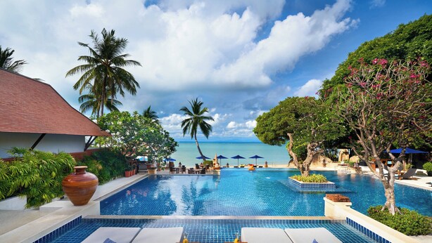 A pool area with lounge chairs, a view of the ocean, and palm trees. - Renaissance Koh Samui Resort & Spa (Koh Samui)