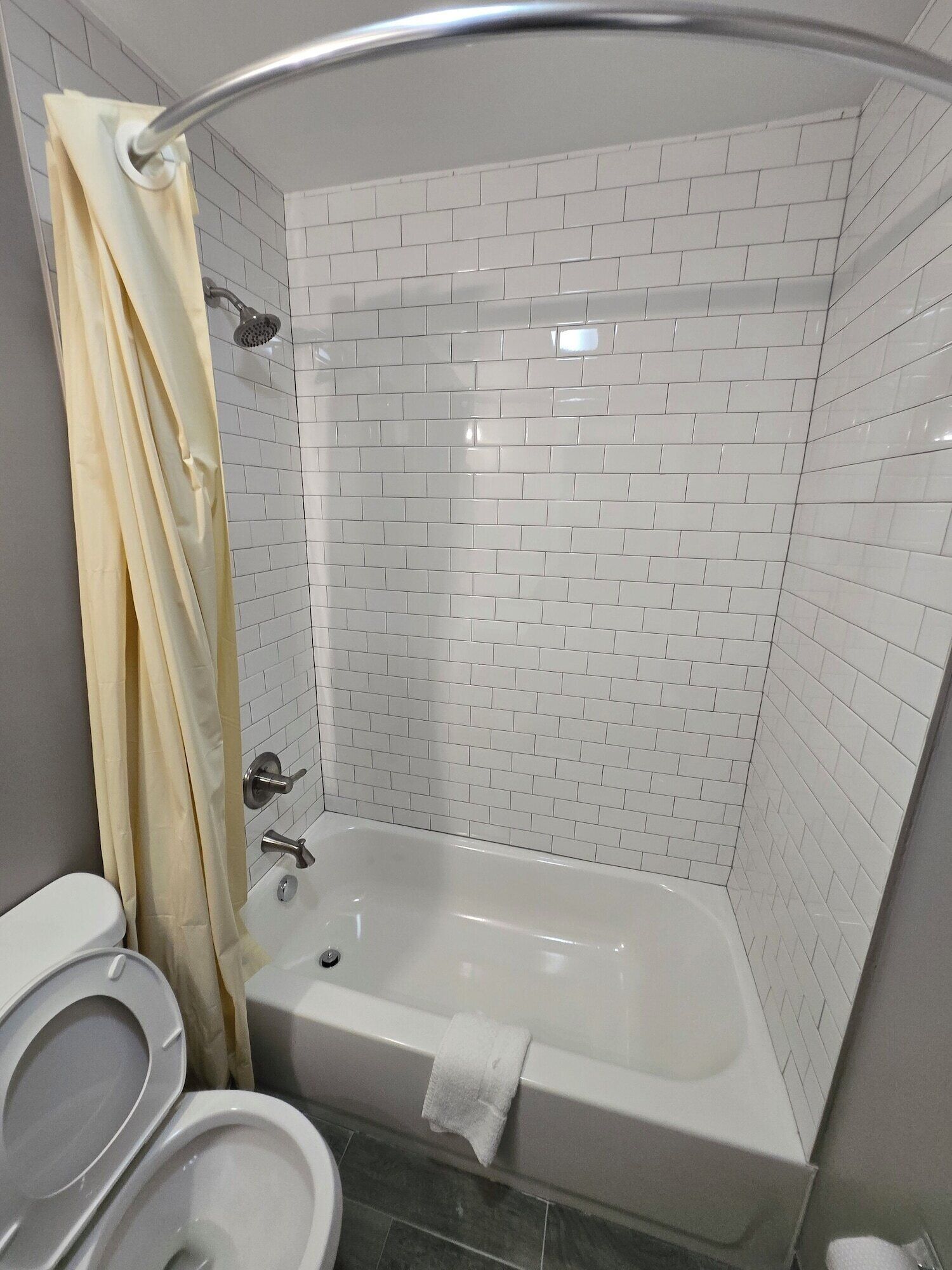 Un baño con una bañera blanca, un inodoro y una cortina de ducha.