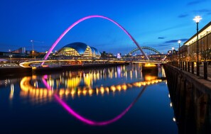 A modern bridge with a distinctive arch and a river reflecting its lights. - Holiday Inn Express Newcastle City Centre by IHG (Newcastle-upon-Tyne)
