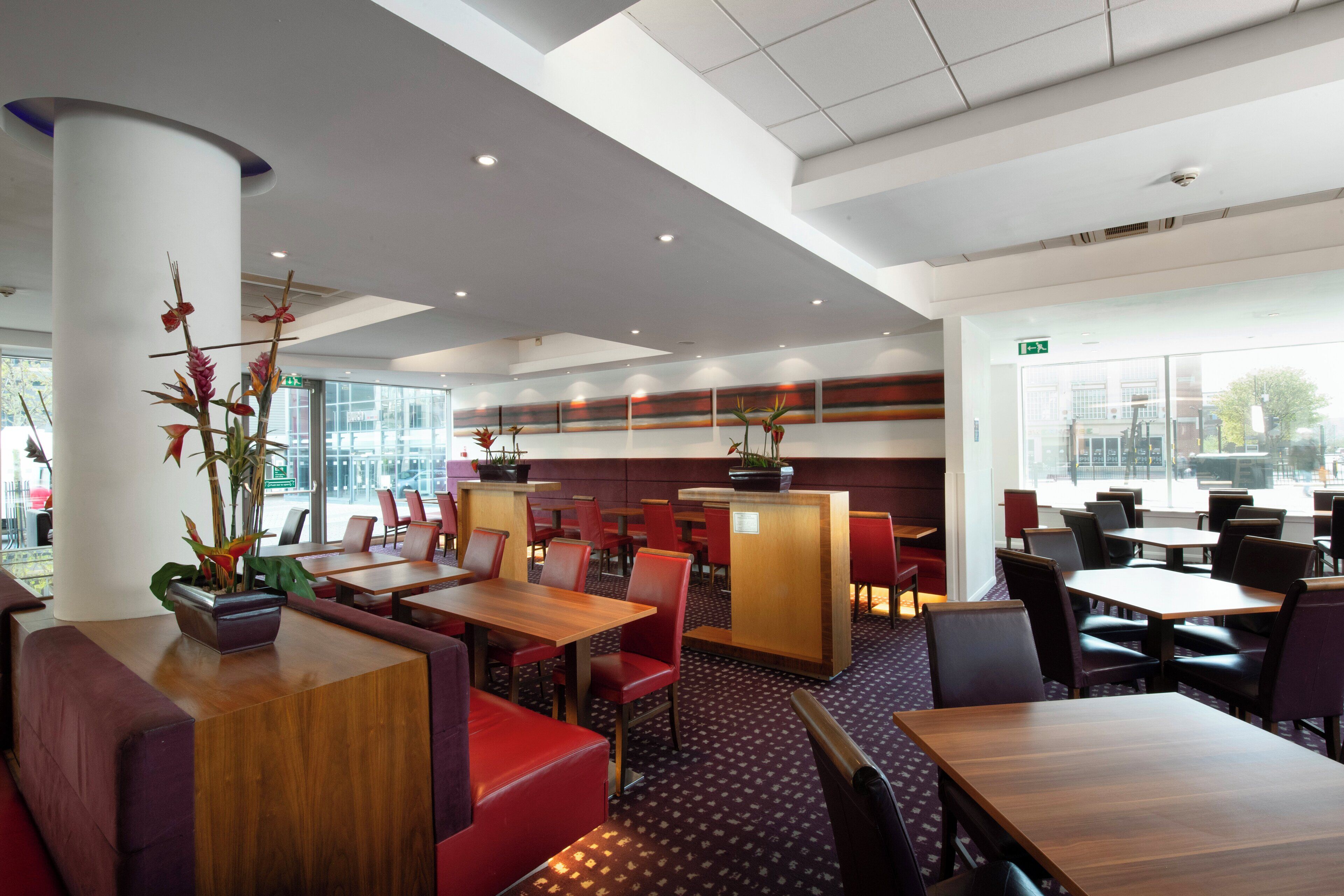 Ein modernes Restaurant mit hohen Decken, viel Platz und großen Fenstern.