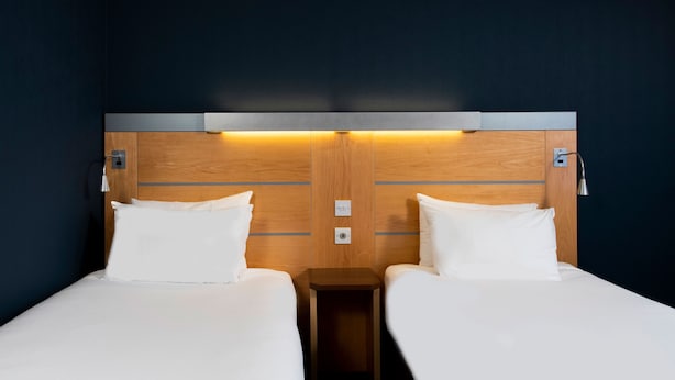 A hotel room with two beds, wooden headboards, and bedside lamps. - Holiday Inn Express Newcastle City Centre by IHG (Newcastle-upon-Tyne)
