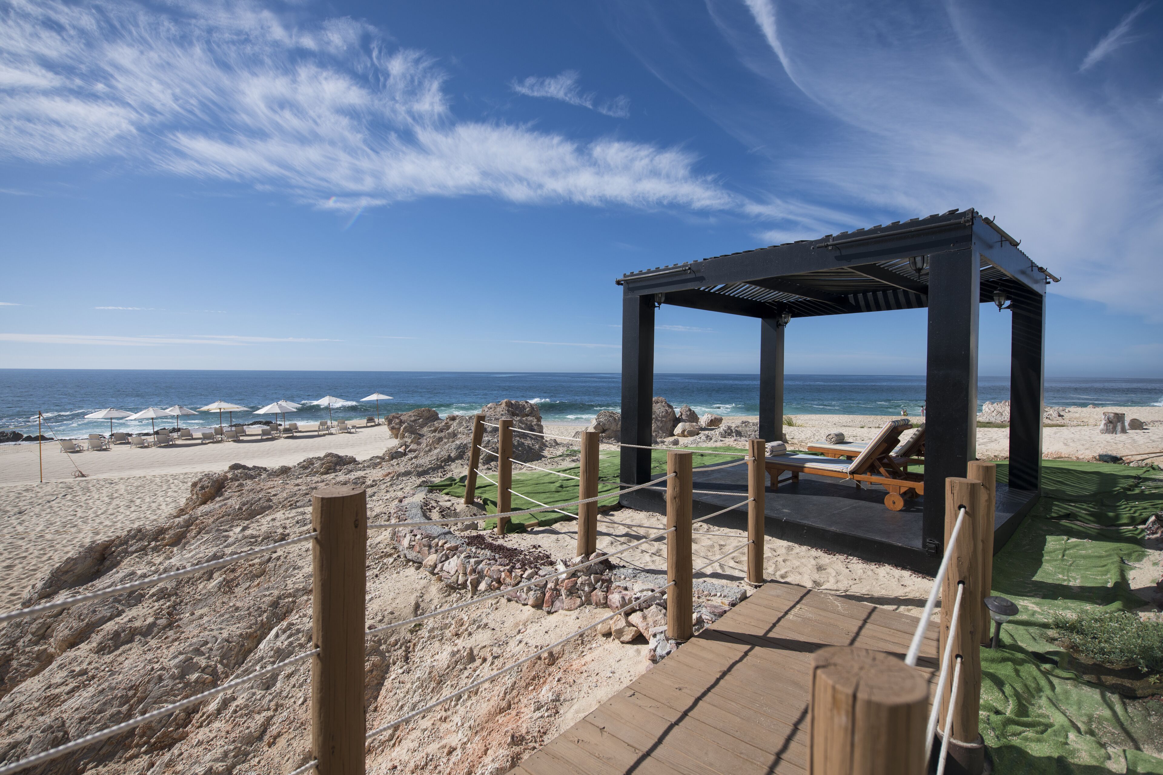Ein Kiosks an einem Strand mit Holzterrasse, mit Blick auf den Ozean.