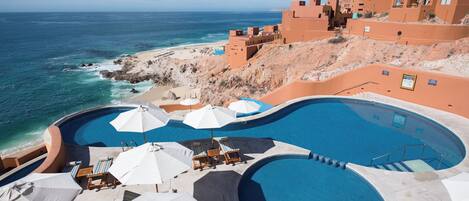 Un resort con varias piscinas, acceso a la playa y arquitectura tradicional.