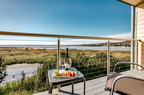 A balcony with a table set for two, featuring a bottle of wine and glasses, and a plate of food. - Panorama Hotel St Helens (St Helens)